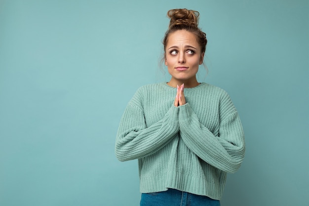 Photo of young beautiful blonde woman with sincere emotions wearing casual blue pullover isolated