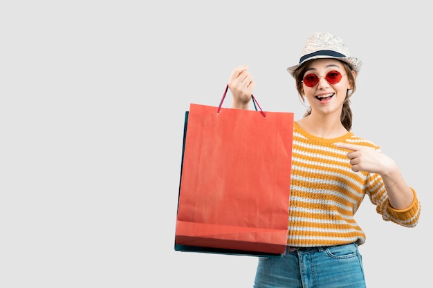 Photo of young brunette woman in sunglasses pointing at shopping bags . High quality photo