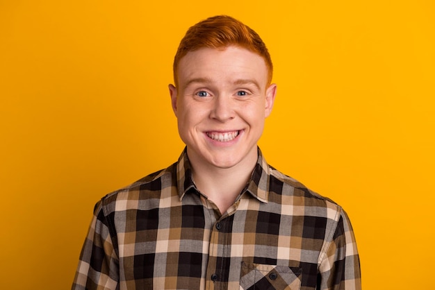 Photo of young cheerful man toothy smile clever wear casual clothes isolated over yellow color background