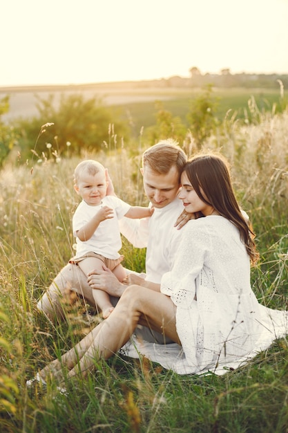 Photo of a young family sitting at the field on a sunny day. 