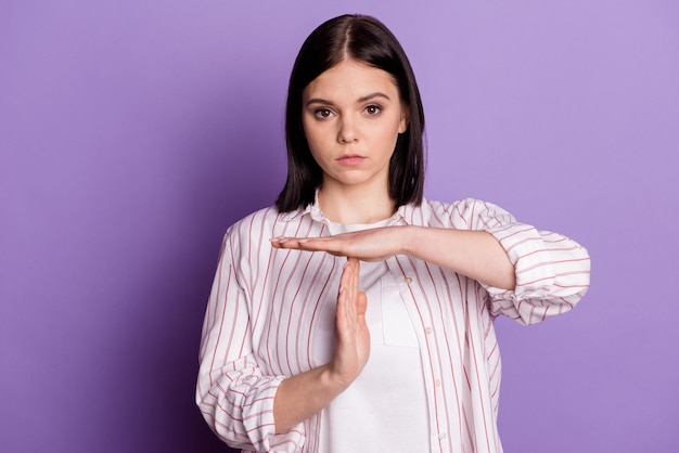 Photo of young girl show arms break limit stop symbol game trainer isolated over violet color background