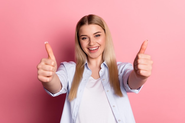 Photo of young girl show thumbsup approve perfect suggest ads rate isolated over pink color background