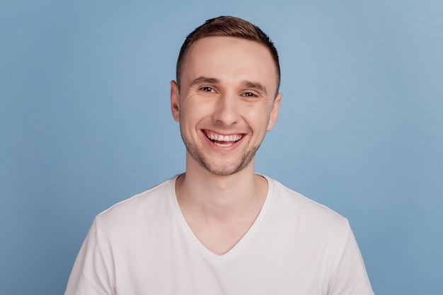 Photo of young handsome cool man happy positive smile cheerful toothy isolated over blue color background