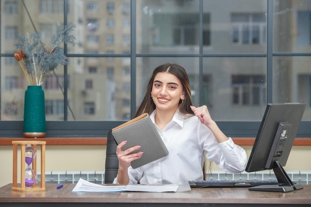 Photo of young lady holding notebook and squeeze her fist