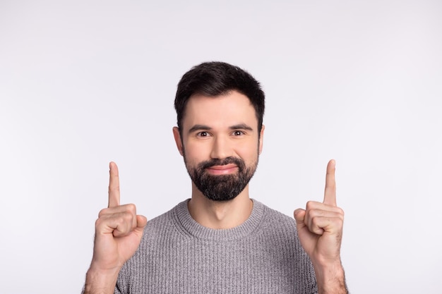 Photo of young man indicate fingers empty space promotion direct advertising isolated over grey color background