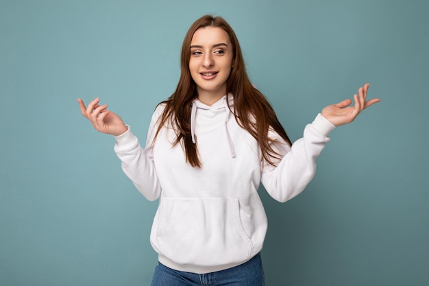 Photo of young positive happy beautiful brunette woman with sincere emotions wearing white hoodie