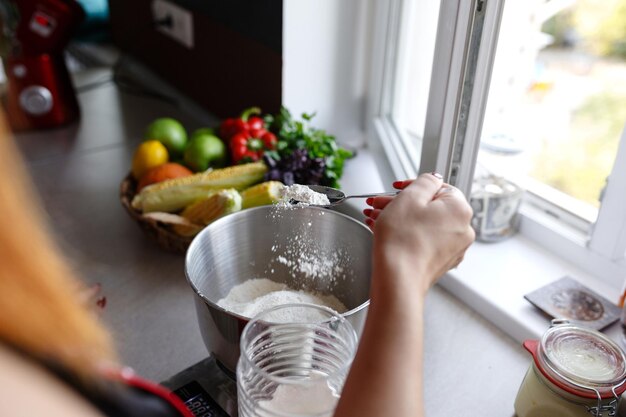 Photo of young pretty lady standing in kitchen while cooking fish Looking aside Preparation of lemon tart