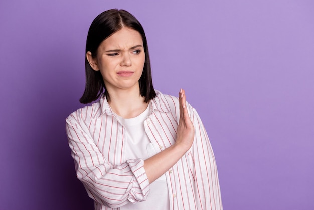 Photo of young woman displeased show hand no stop rejection sign look empty space isolated over violet color background