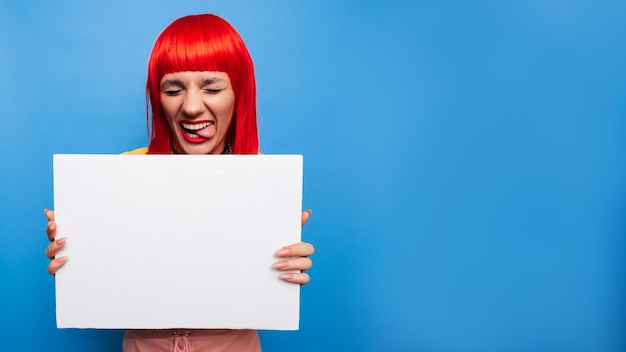 Photo of a young woman A happy positive girl is holding a poster or banner for an advertising promo with a clean and empty space