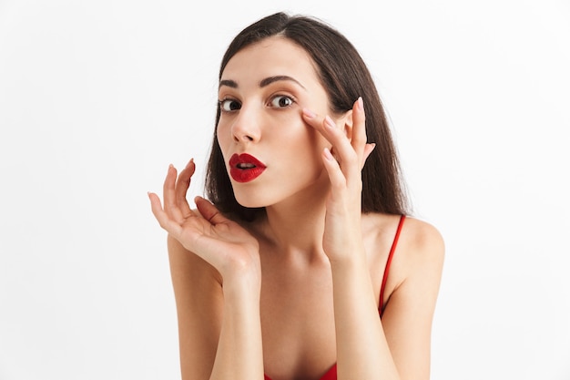 Photo of young woman posing isolated looking at mirror doing makeup.