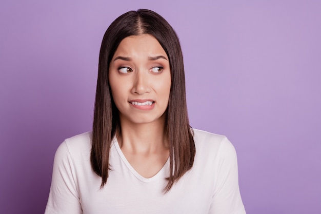 Photo of young woman unhappy sad upset negative moody bite lips teeth fail isolated over violet color background