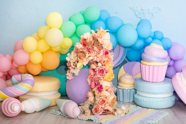 Photo zone for the first birthday. balls, number 1, one from flowers. decorative sweets and cakes. pastel colors.