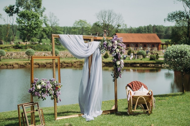 Photo zone at a wedding near the lake with a chair.summer wedding Decoration for guests.