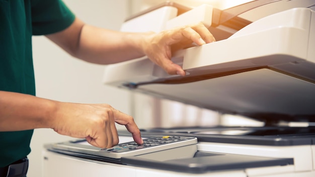 Photocopier printer Close up hand office man press copy button on panel to using the copier or photocopy machine for scanning document or printing paper or Xerox a sheet