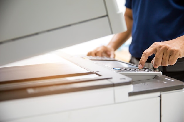 Photocopier printer Close up hand office man press copy button on panel to using the copier or photocopy machine for scanning document or printing paper or Xerox a sheet