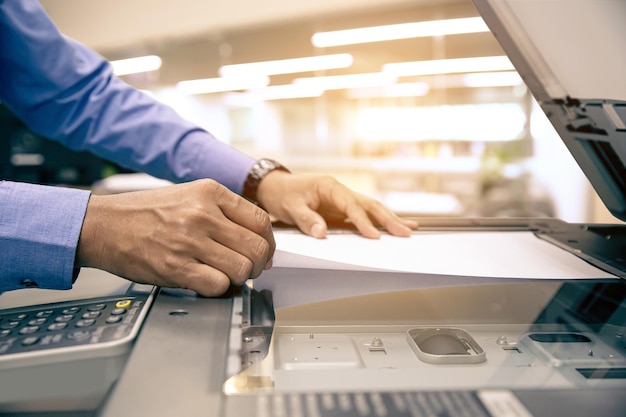 Photocopier printer Close up hand office man scanning paper on the copier or photocopy machine concept of scanner document or printing or Xerox a sheet