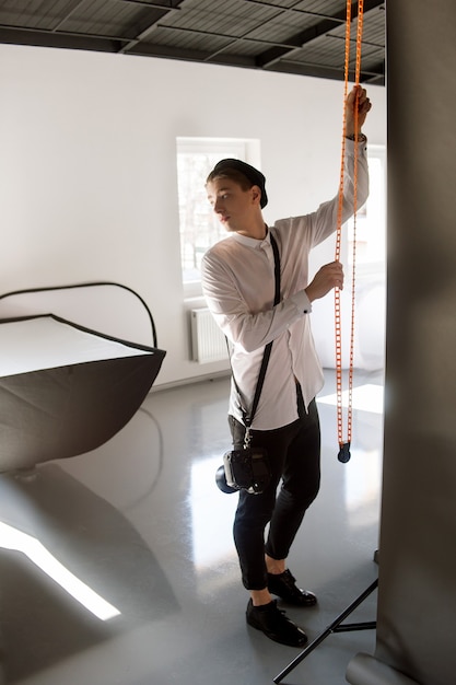 Photographer assistant setting the screen for studio shooting