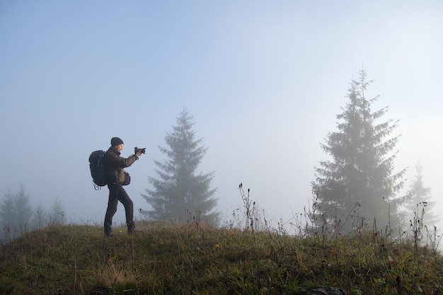 Photographer hiker taking picture of nature with digital camera