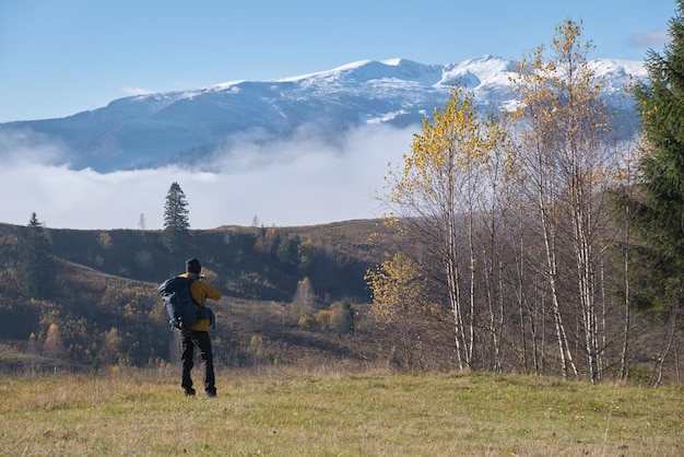 Photographer hiker taking picture of nature with digital camera