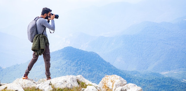 Photographer holding the camera in mountains