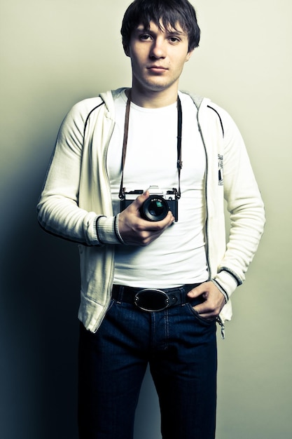 Photographer holding the film camera on light background