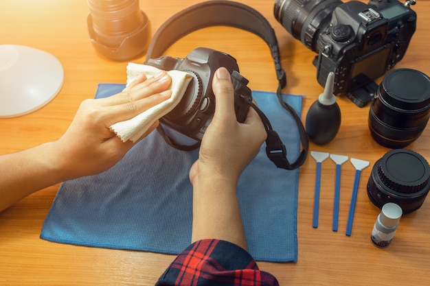 The photographer is cleaning his camera by himself. 