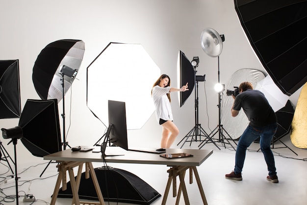 Photographer and model working in studio.