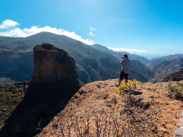 A photographer at the Roque Palmes viewpoint near Roque Nublo in Gran Canaria Canary Islands