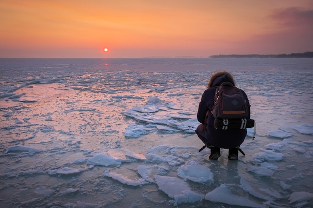 Photographer take pictures on the ice during sunset