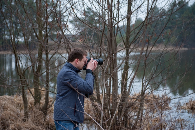 A photographer takes pictures of the landscape, an overcast photo of nature, a photographer at work