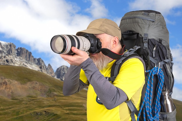 photographer traveler with a backpack photographs the beauty of nature on a journey