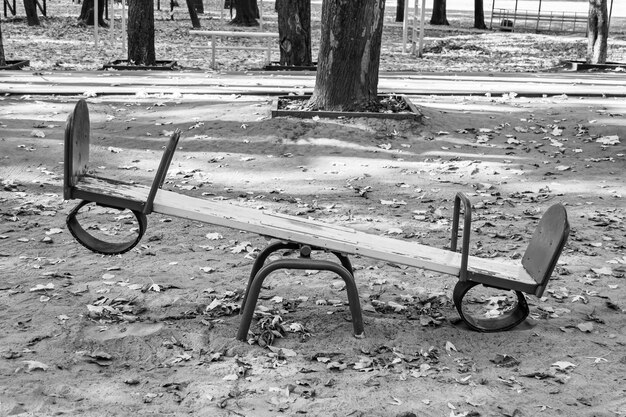 Photography on theme empty playground with metal swing for kids on background natural nature photo consisting from playground with steel swing swing on old playground in countryside without people