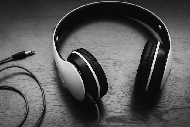 Photos Black headphones on old wooden table