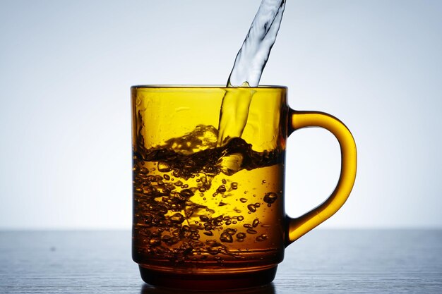 Photos pour water in a tea or brown glass