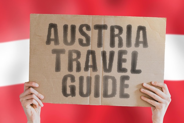 The phrase Austria travel guide on a banner in mens hand with Austrian flag Worldwide Terminal