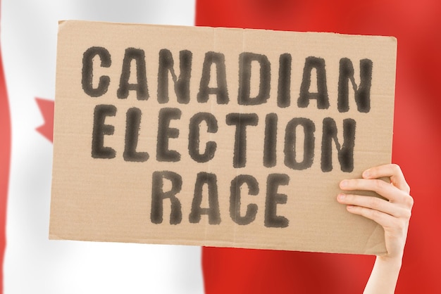 The phrase " Canadian election race " on a banner in men's hand with blurred Canadian flag on the background. Ballot box.  Politics. Conflict. Politic. Primary. Selection. Choosing. Ottawa