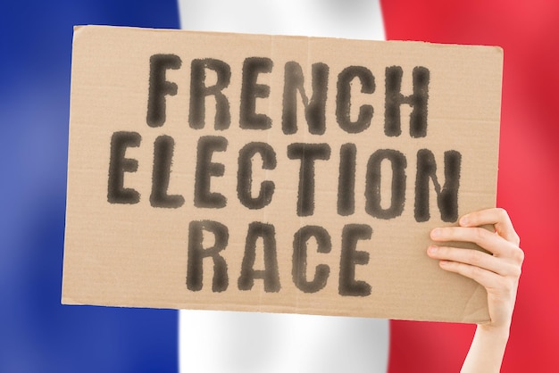 The phrase " French election race " on a banner in men's hand with blurred French flag on the background. Ballot box. Eurozone.  Politics. Conflict. Politic. Primary. Selection. Choosing. Europe