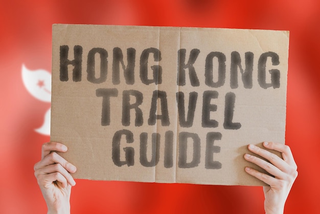 The phrase Honk Kong travel guide on a banner in mens hand with Honk Kong flag Worldwide Terminal