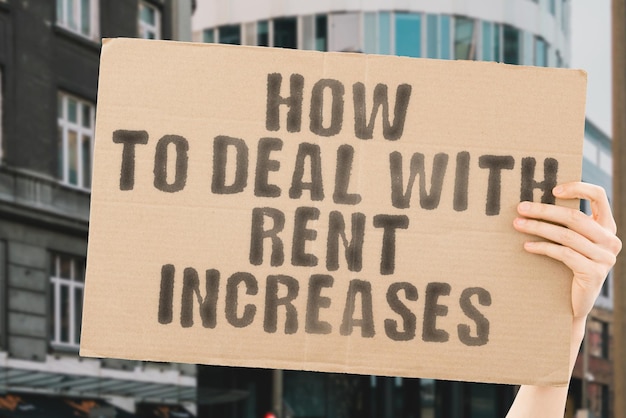 The phrase How to deal with rent increases on a banner in mens hand Realty Raise Paying Pay