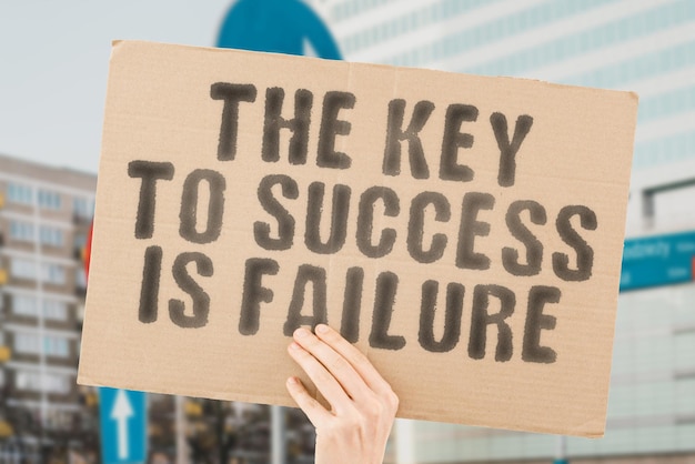 The phrase The key to success is failure on a banner in men's hands with blurred background Potential Process Progress Promotion Result Rise Secret Security Skill Solution Step