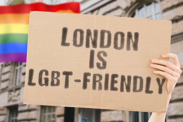 The phrase  London is LGBTFriendly  on a banner in mens hand with blurred LGBT flag