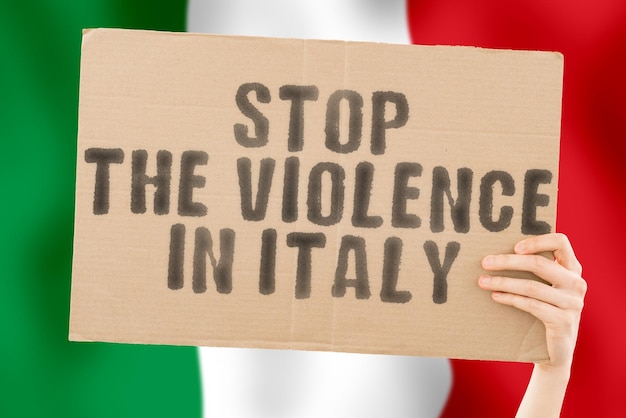 The phrase Stop the violence in Italy is on a banner in men's hands with a blurred Italian flag in the background Sad Rights Security Social Stress Combat Hate Cruelty