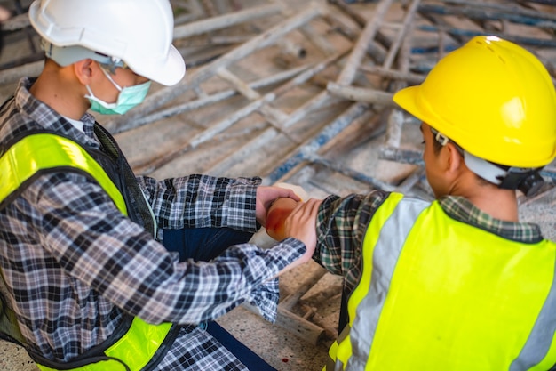 Physical injury at work of construction worker. Injury bleeding from work accident in pile of scaffolding steel falling down to impinge the arm.