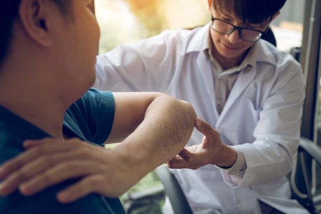 Photo physical therapists are checking patients elbows at the clinic office room