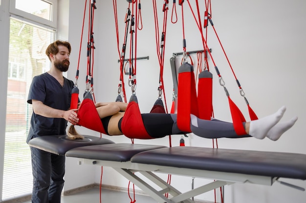 Physiotherapist assists female patient undergoing rehabilitative physiotherapy