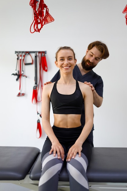 Physiotherapist doctor carefully examines the neck and shoulders of his female patient for defects