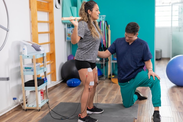 Physiotherapist doctor checking his patient's legs while doing rehabilitation exercises in clinic