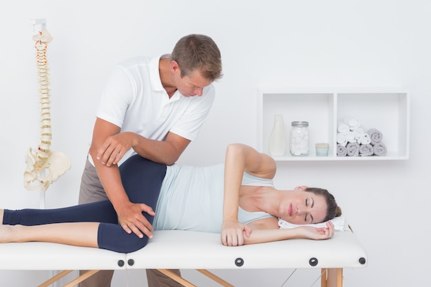 Physiotherapist doing leg massage to his patient