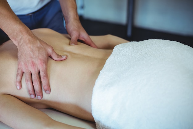 Physiotherapist giving back massage to a woman