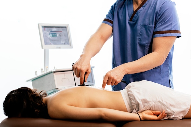 Physiotherapist giving backstroke therapy to a woman in clinic. Physical treatment concept